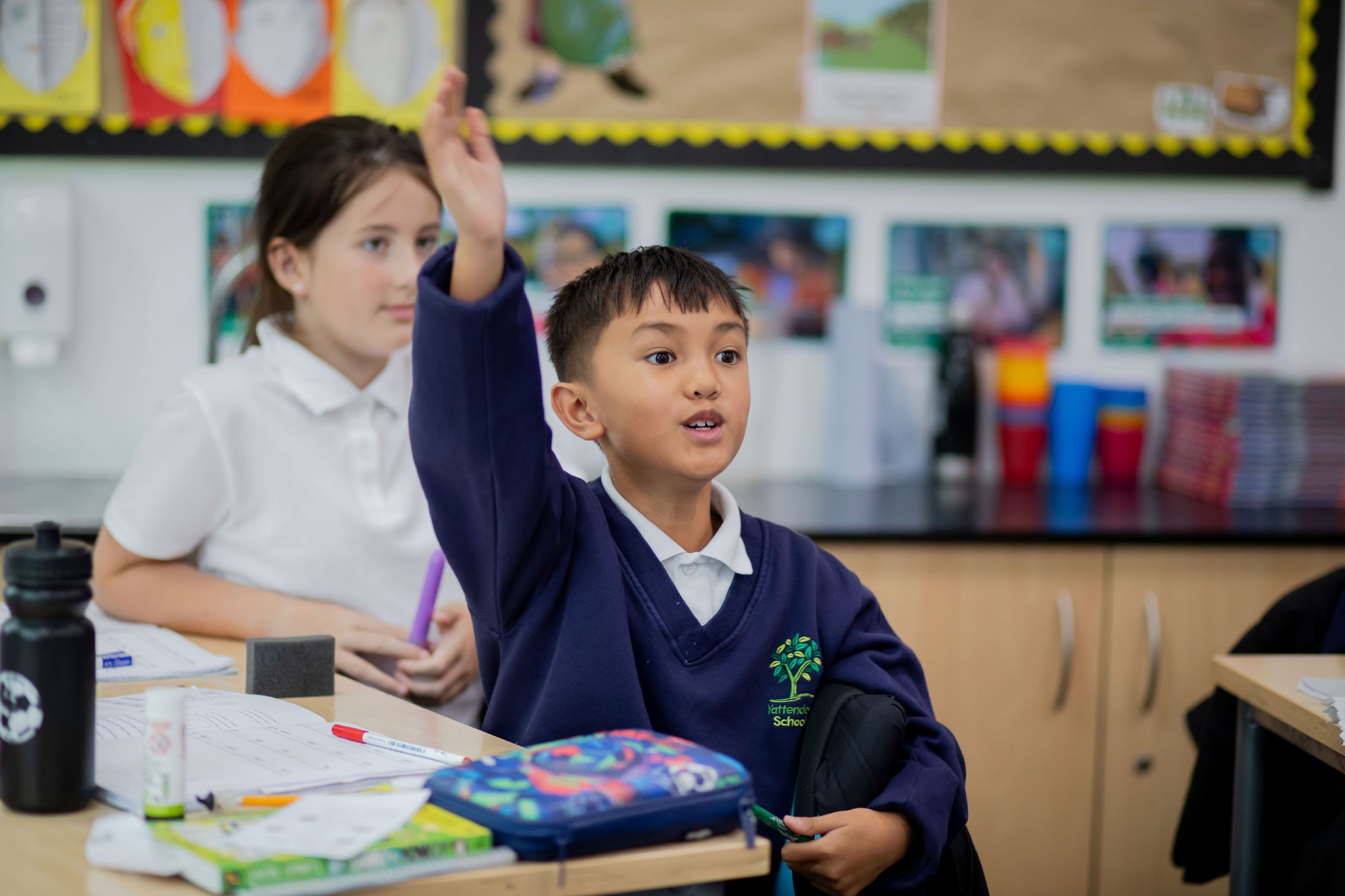 Child from Yattendon School in a classroom with his hand up to answer a question